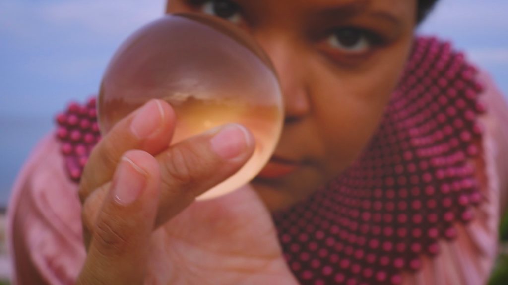 Elizabeth A. Baker holding a small object in front of her face.