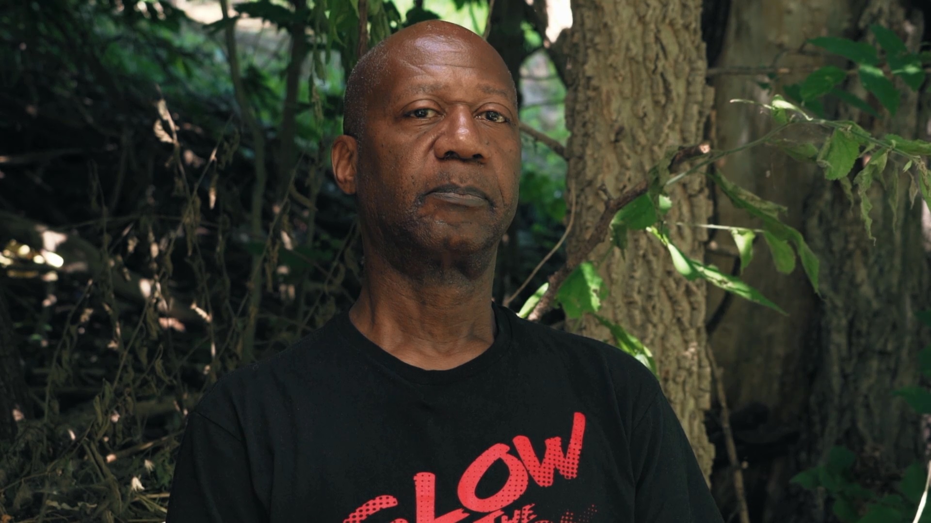 Dereck Higgins standing outside near trees.