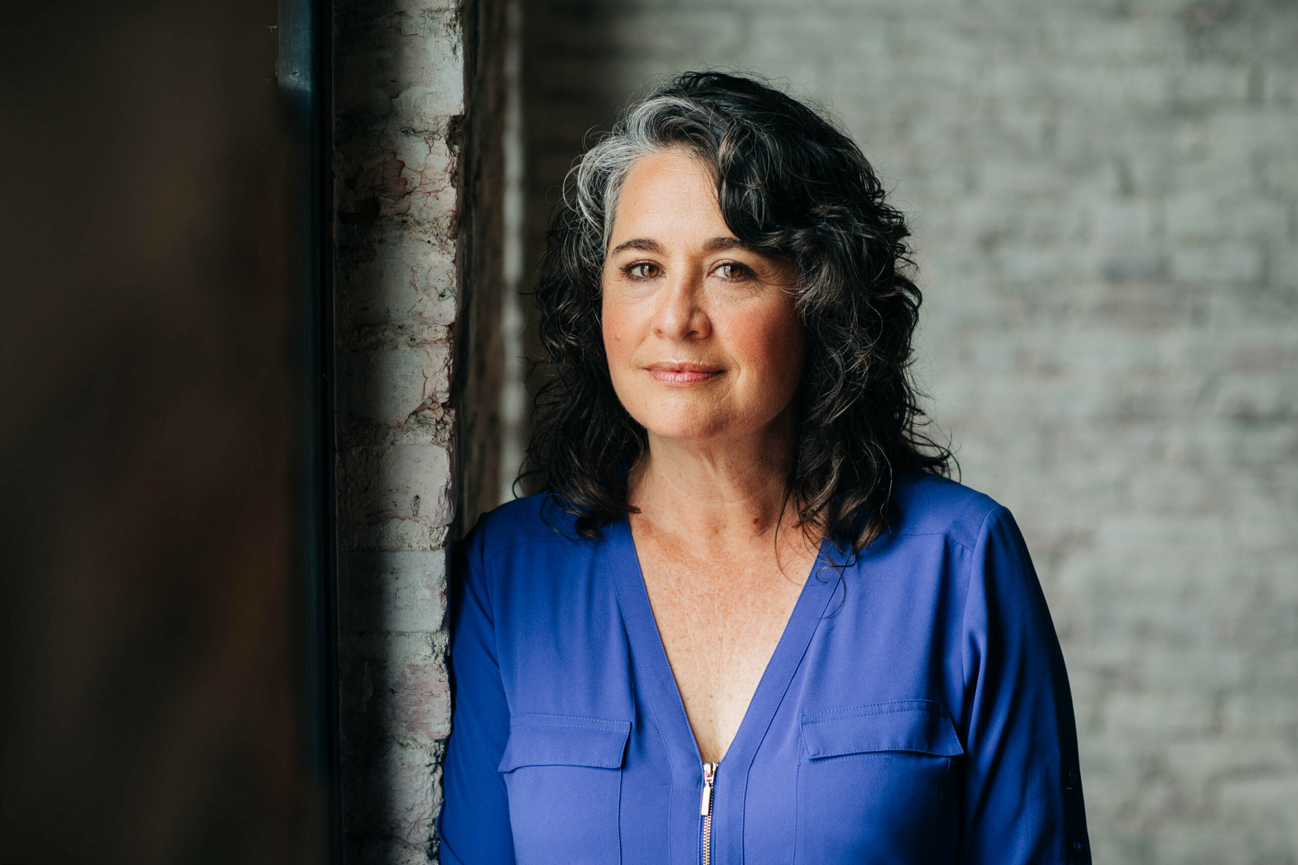 Diane Downs standing in front of a brick wall.