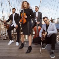 String quartet posing on outdoors with a bridge-like structure and suspended cables