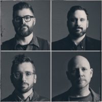 A foursquare black-and-white photo of four men