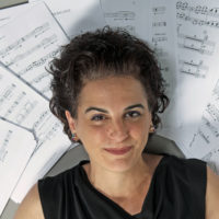 A woman laying her head against sheet music