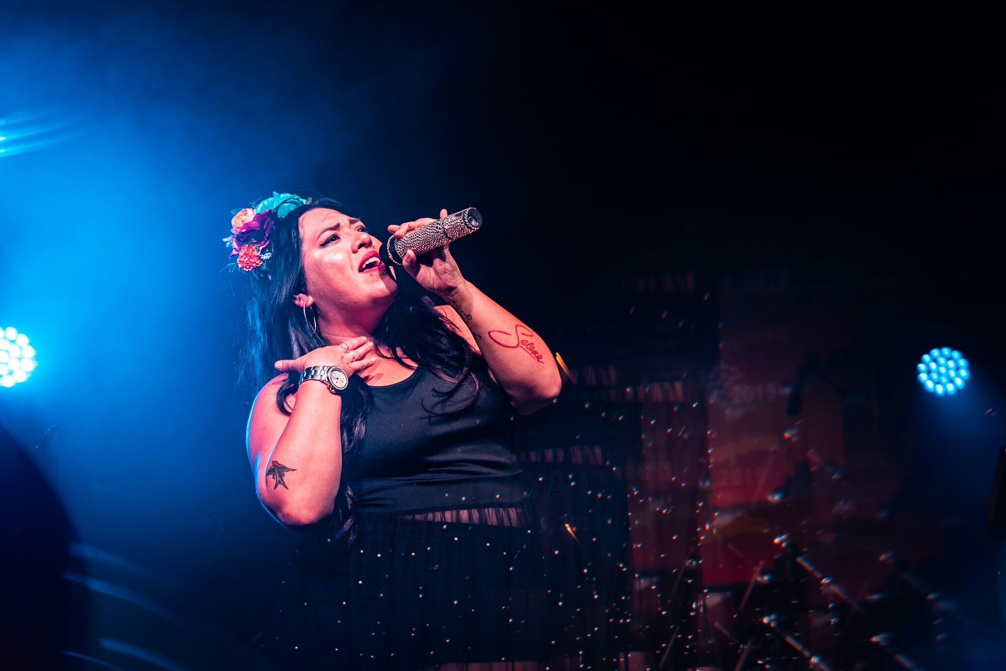 Stephanie Bergara on stage singing with a microphone.